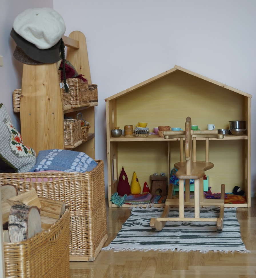 Jaukus žaidimų kampelis Valdorfo darželyje su natūralių medžiagų žaislais.